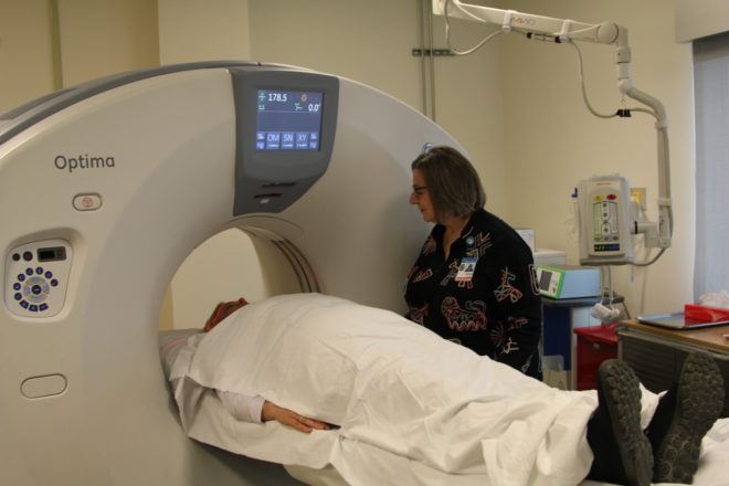 NSHC's Cathy DeAngelis with CT scan machine which is slightly smaller than the new MRI machine . Photo credit: Davis Hovey